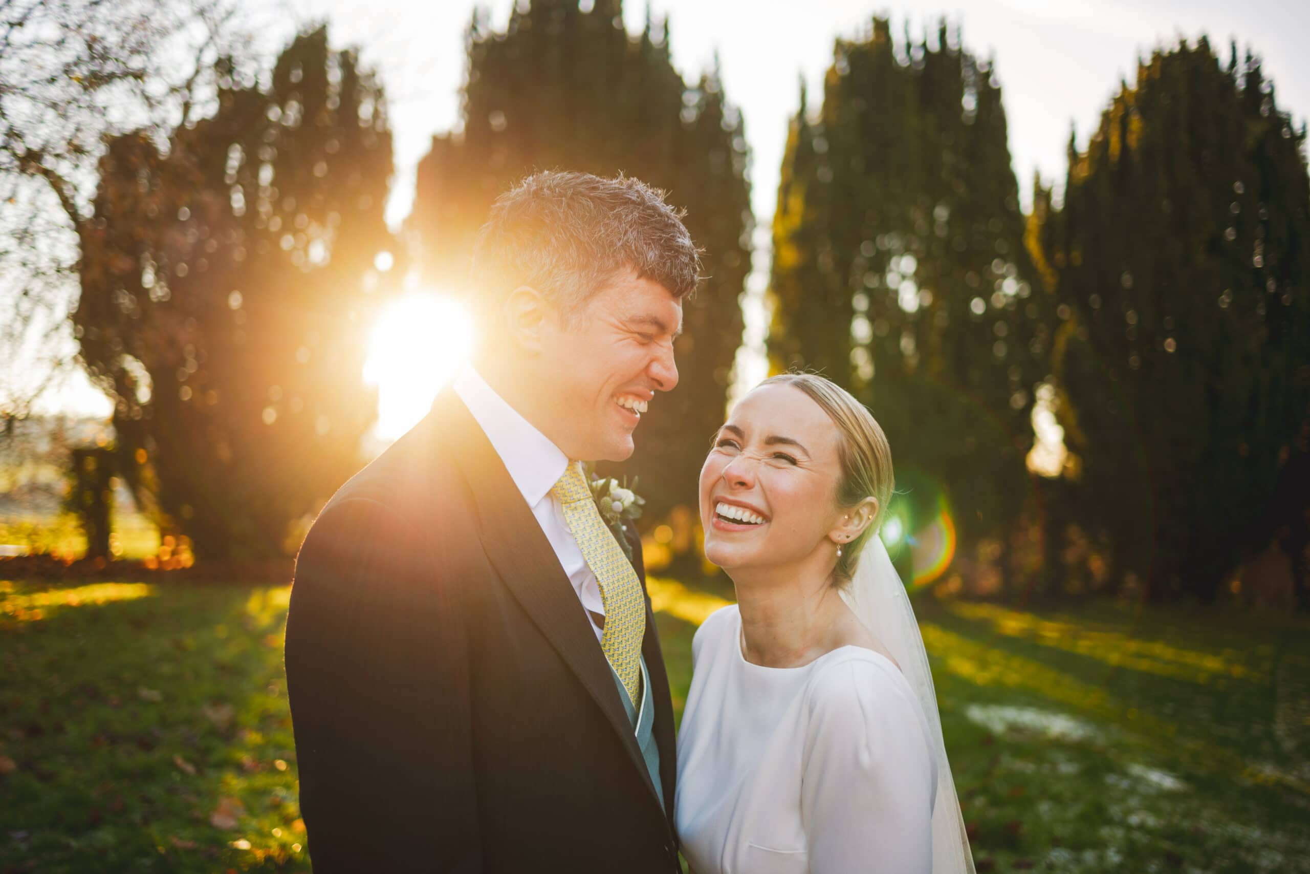 A wedding couple smiling at the sun outside a Church in Syrencot