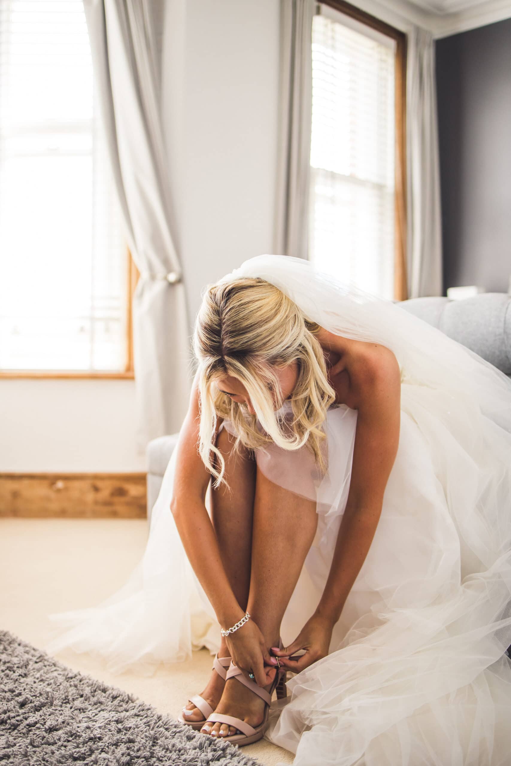 A bride putting on her wedding shoes before heading to her ceremony