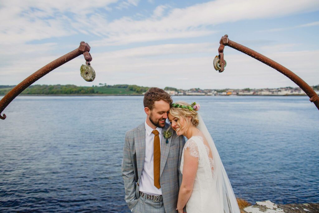 A man and woman standing next to each other at the Strangford Lough for their Old Court Chapel Wedding